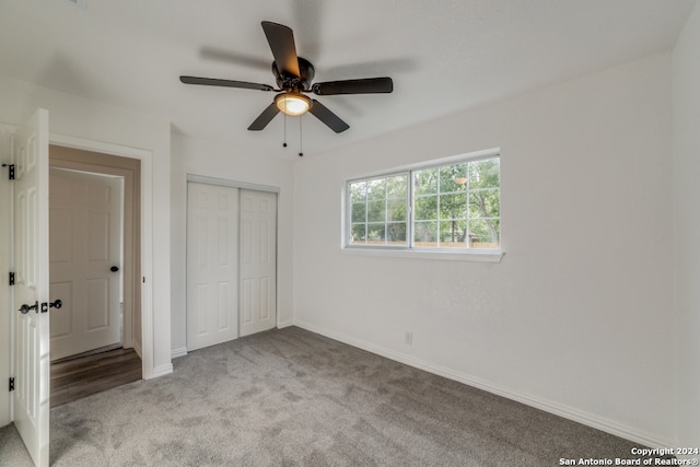 unfurnished bedroom with ceiling fan, light carpet, and a closet