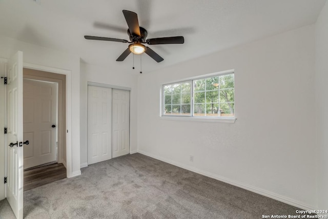 unfurnished bedroom with light colored carpet, a closet, ceiling fan, and baseboards