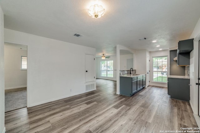 kitchen with a healthy amount of sunlight, light countertops, a sink, and gray cabinets