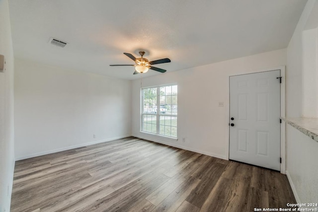 entryway with baseboards, visible vents, wood finished floors, and a ceiling fan