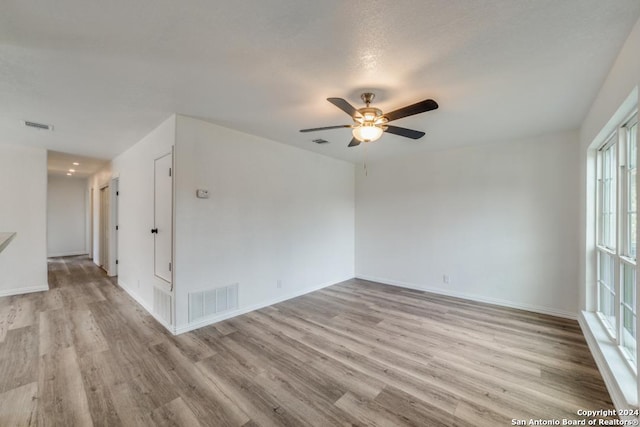 unfurnished room featuring visible vents, wood finished floors, and ceiling fan