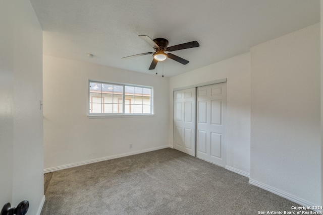 unfurnished bedroom with ceiling fan, light carpet, and a closet