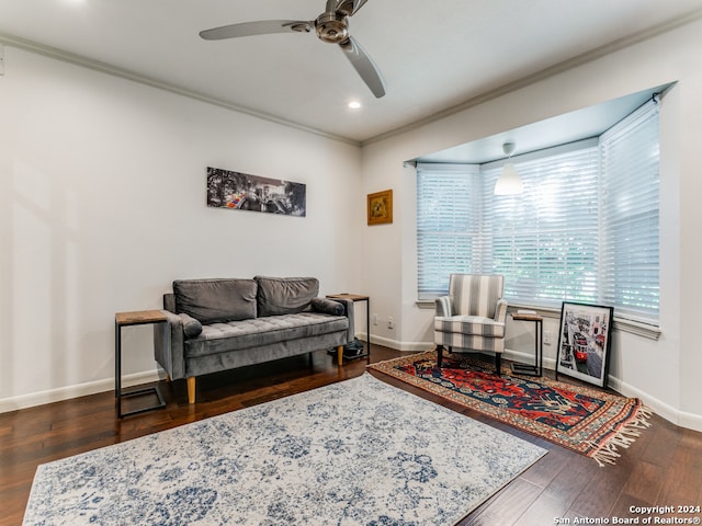 living room featuring ceiling fan, dark wood-type flooring, and crown molding