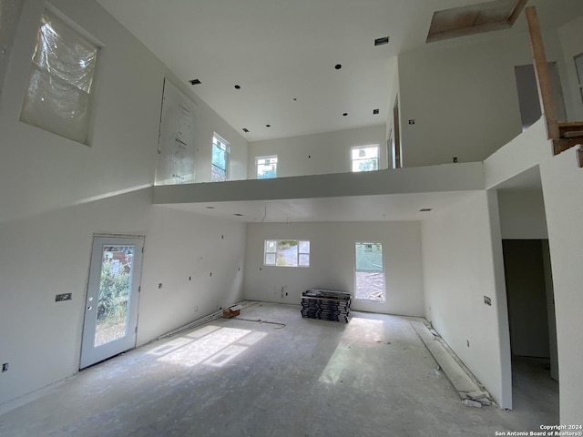 empty room featuring visible vents and a towering ceiling