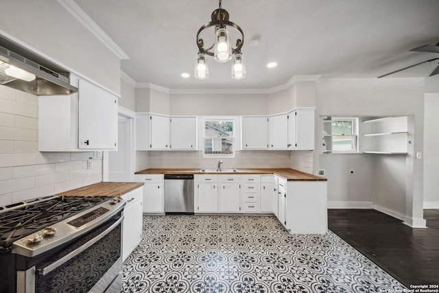 kitchen with ceiling fan with notable chandelier, appliances with stainless steel finishes, decorative light fixtures, and white cabinetry