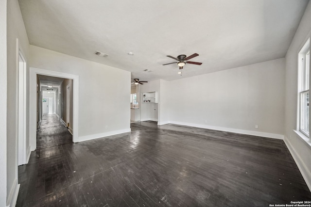 unfurnished living room featuring ceiling fan and dark hardwood / wood-style floors