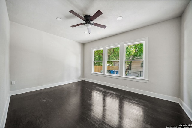 empty room with ceiling fan and dark hardwood / wood-style floors