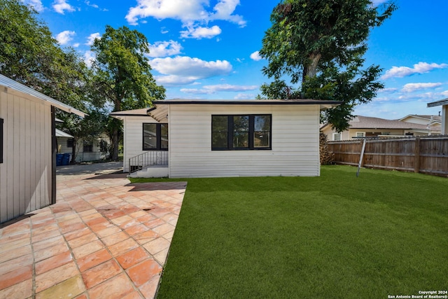 rear view of property with a lawn and a patio area