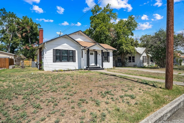 view of front of house with a front lawn and central AC