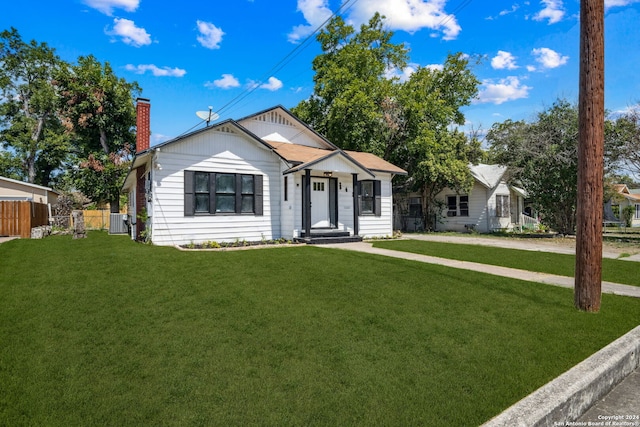 view of front of property with a front lawn and central air condition unit