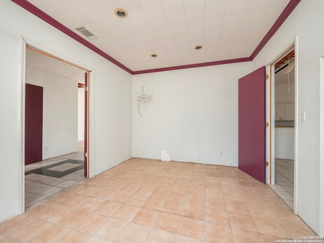 tiled spare room with ornamental molding