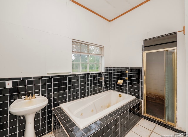 bathroom with tile walls, independent shower and bath, and tile patterned floors