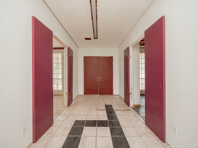 hallway with light tile patterned flooring and plenty of natural light