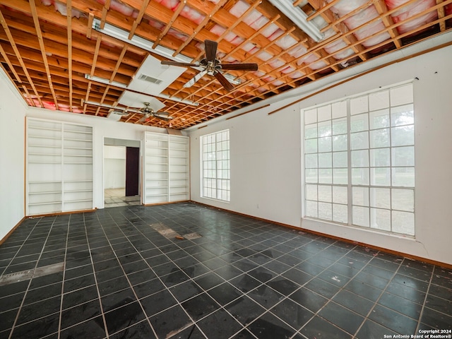 unfurnished living room with ceiling fan and plenty of natural light