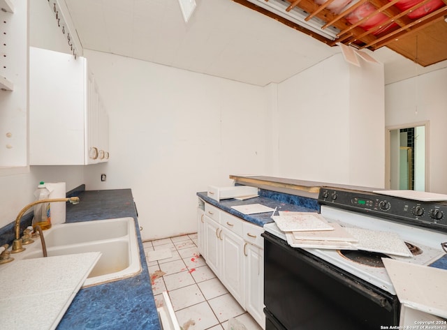 kitchen with sink, white electric stove, and white cabinetry