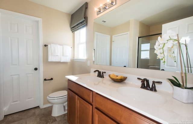 bathroom with vanity, toilet, and a shower with shower door