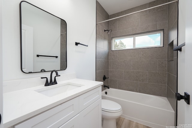 full bathroom featuring vanity, toilet, hardwood / wood-style flooring, and tiled shower / bath