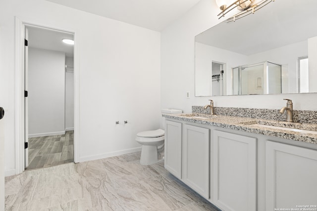 bathroom with a shower with door, toilet, and vanity