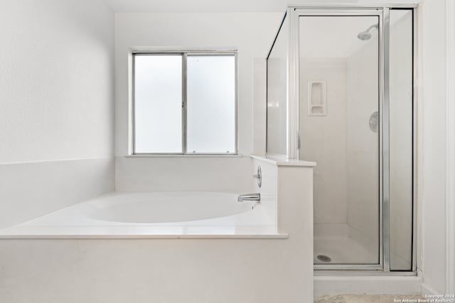 bathroom featuring separate shower and tub