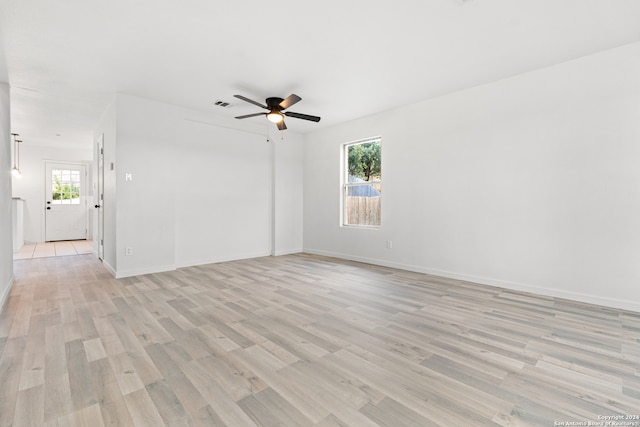 unfurnished room featuring a wealth of natural light, ceiling fan, and light wood-type flooring