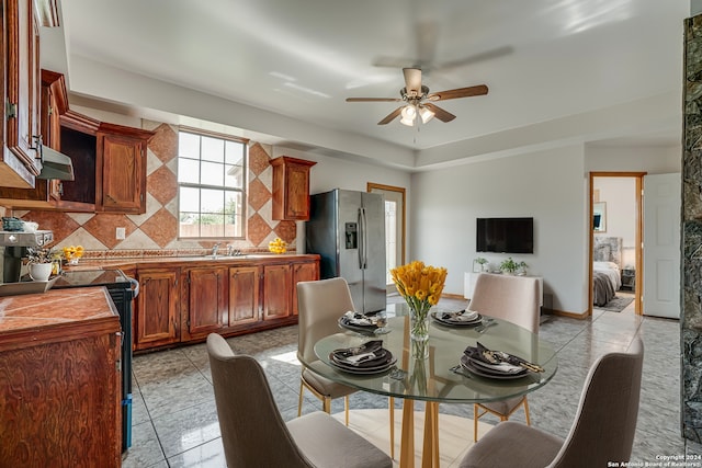 dining space featuring ceiling fan, light tile patterned floors, and sink