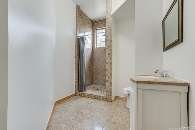 bathroom with tile patterned floors, curtained shower, vanity, and toilet