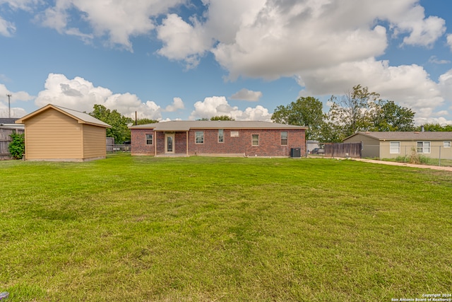 back of property with a lawn and central AC