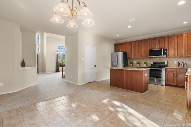 kitchen with decorative light fixtures, backsplash, stainless steel appliances, a center island, and an inviting chandelier