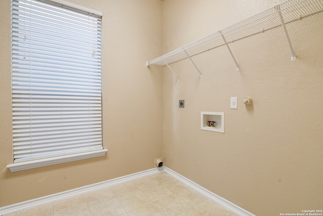 clothes washing area featuring washer hookup, hookup for an electric dryer, light tile patterned flooring, and gas dryer hookup