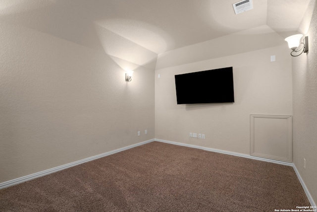 carpeted spare room with vaulted ceiling