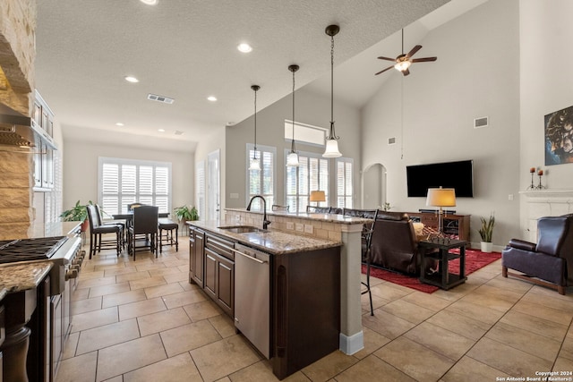 kitchen featuring sink, a kitchen breakfast bar, stainless steel appliances, dark brown cabinetry, and ceiling fan