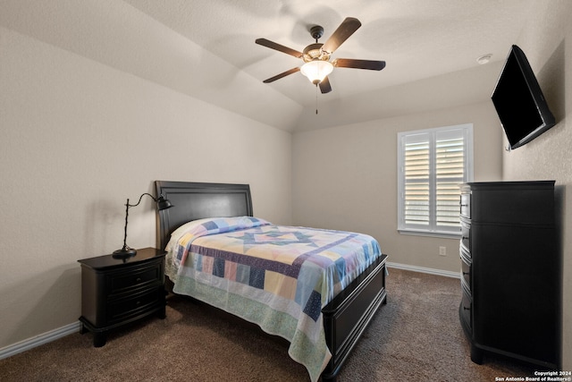 bedroom featuring vaulted ceiling, dark colored carpet, and ceiling fan