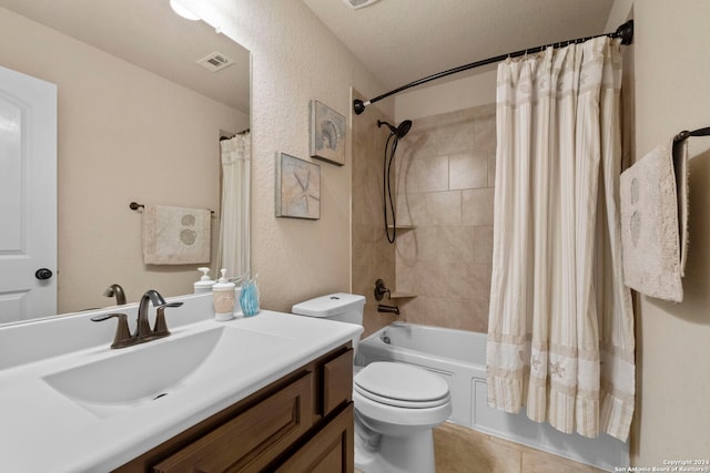 full bathroom featuring vanity, a textured ceiling, shower / bathtub combination with curtain, tile patterned floors, and toilet