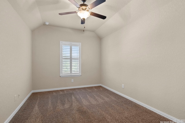 carpeted spare room featuring ceiling fan and vaulted ceiling