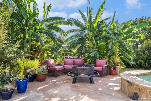 view of patio with an outdoor living space with a fire pit