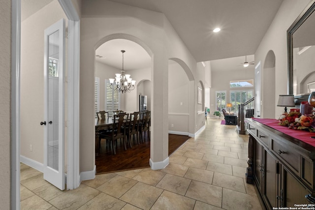 corridor with an inviting chandelier and light hardwood / wood-style floors