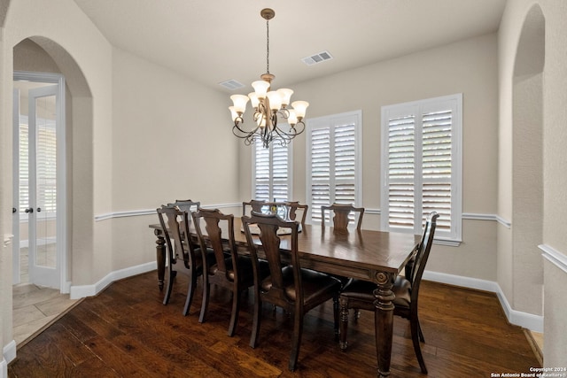 dining room featuring a notable chandelier, dark hardwood / wood-style floors, and a healthy amount of sunlight