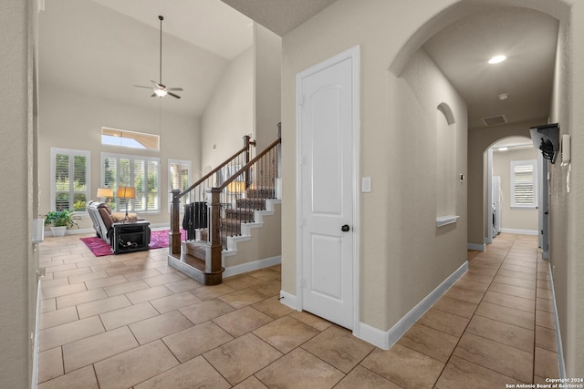 interior space featuring high vaulted ceiling and light tile patterned flooring