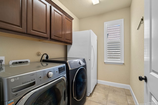 washroom with separate washer and dryer, cabinets, a textured ceiling, and light tile patterned flooring