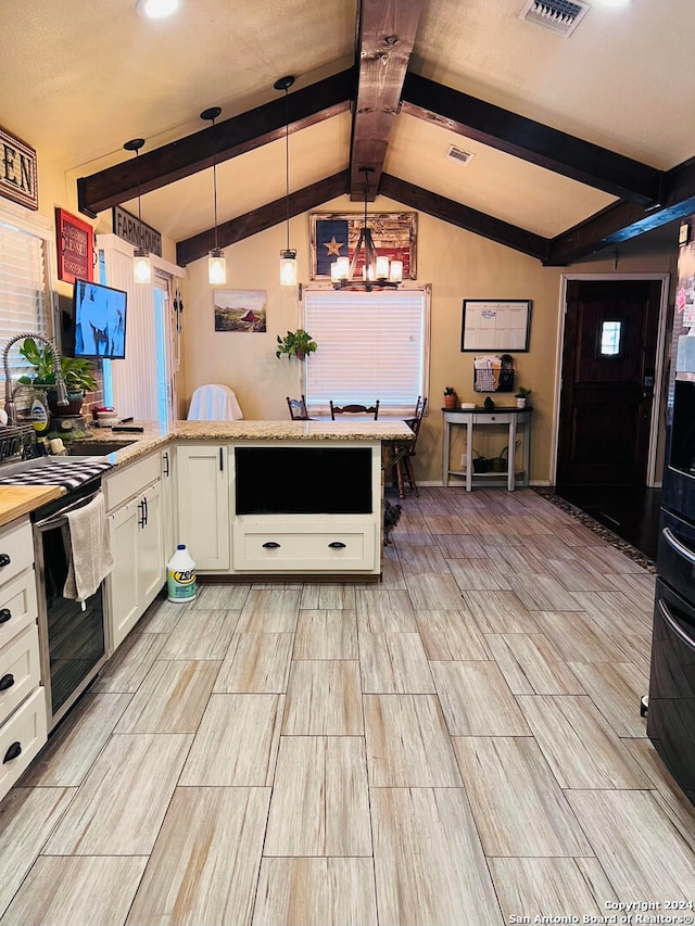 kitchen with white cabinets, an inviting chandelier, light stone countertops, pendant lighting, and lofted ceiling with beams