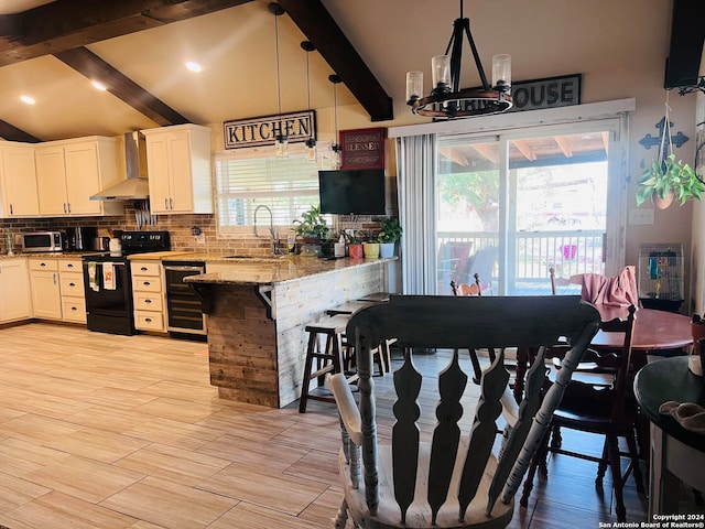 kitchen featuring wall chimney exhaust hood, white cabinets, black / electric stove, and pendant lighting