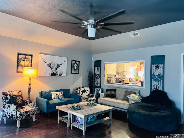 living room featuring ceiling fan, hardwood / wood-style flooring, and a textured ceiling