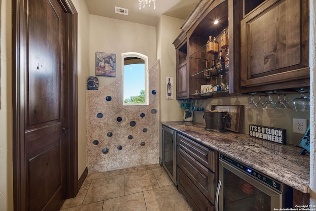 kitchen with dark brown cabinetry, wine cooler, and dark stone counters