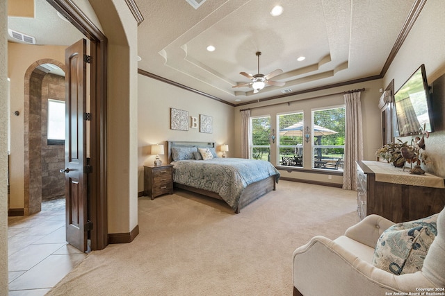 bedroom featuring a textured ceiling, light tile patterned flooring, a raised ceiling, crown molding, and ceiling fan