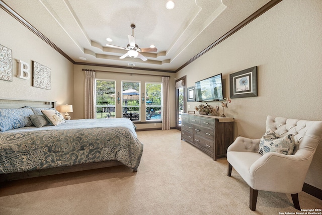 carpeted bedroom with ceiling fan, a textured ceiling, a tray ceiling, and crown molding