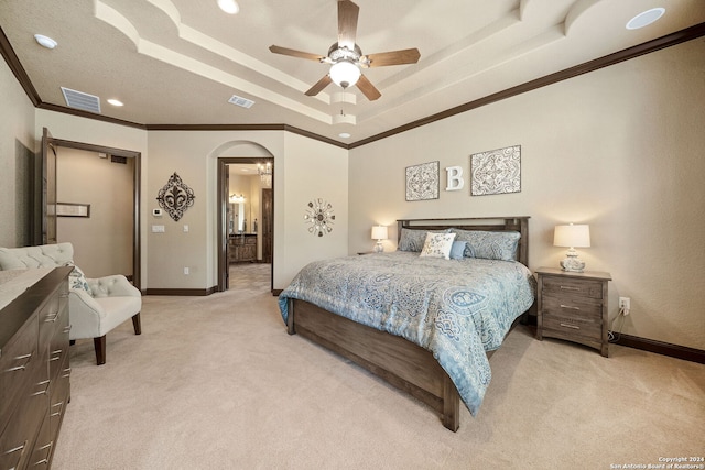 bedroom with light carpet, a tray ceiling, ceiling fan, and crown molding