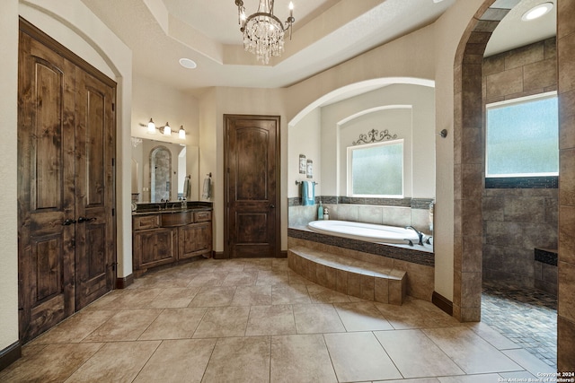 bathroom with an inviting chandelier, vanity, shower with separate bathtub, and a healthy amount of sunlight