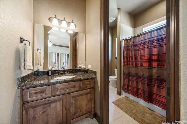 bathroom with curtained shower, vanity, tile patterned flooring, ceiling fan, and toilet