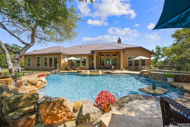 view of swimming pool with an in ground hot tub, a patio, and pool water feature