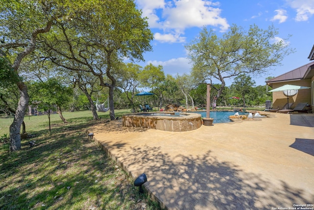 view of yard with a swimming pool with hot tub